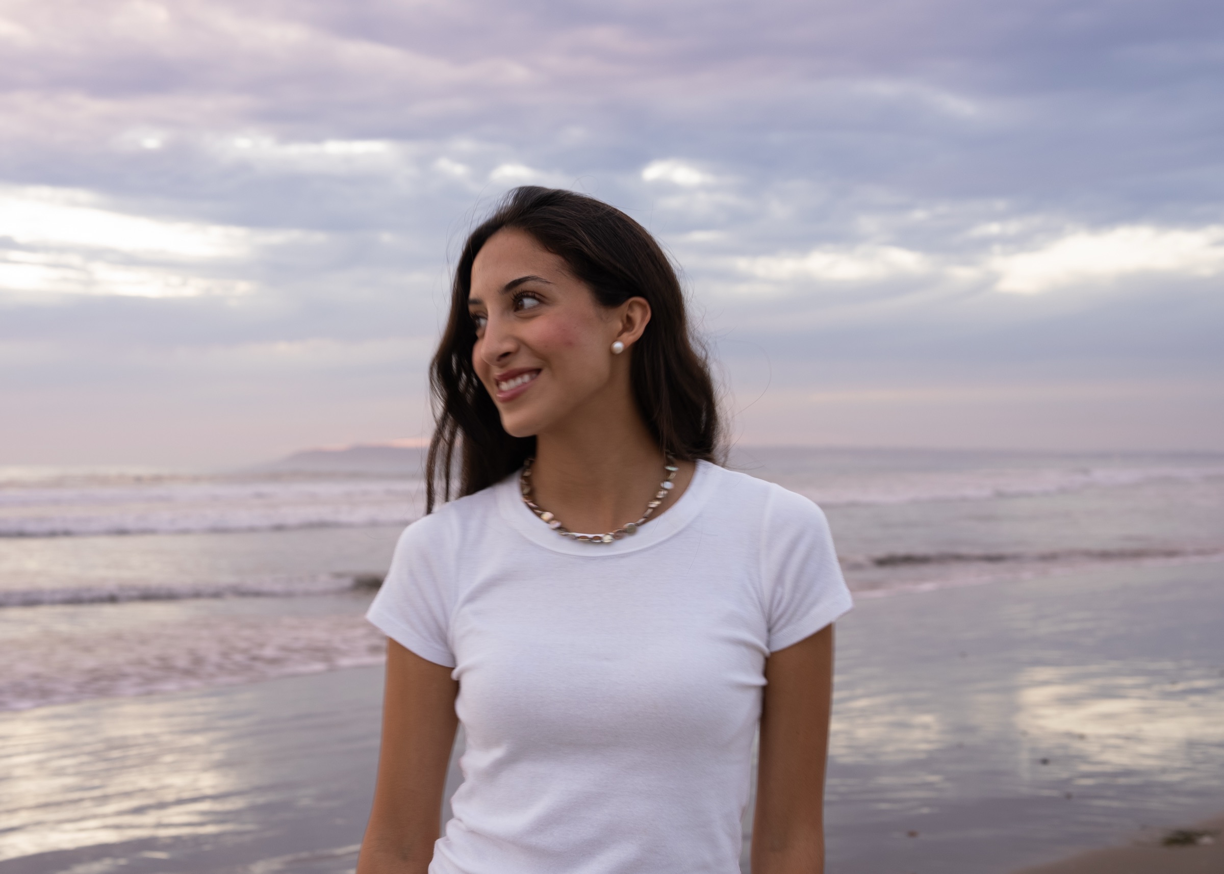 A woman smiling on the beach at dusk