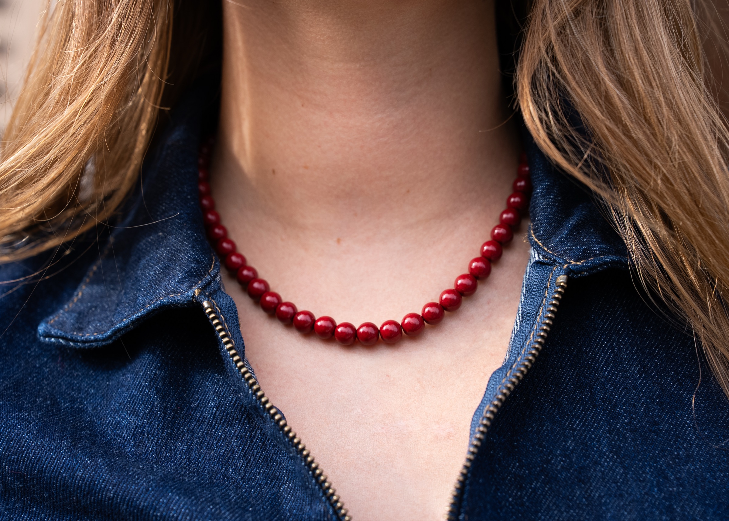 A red beaded Almara necklace against denim