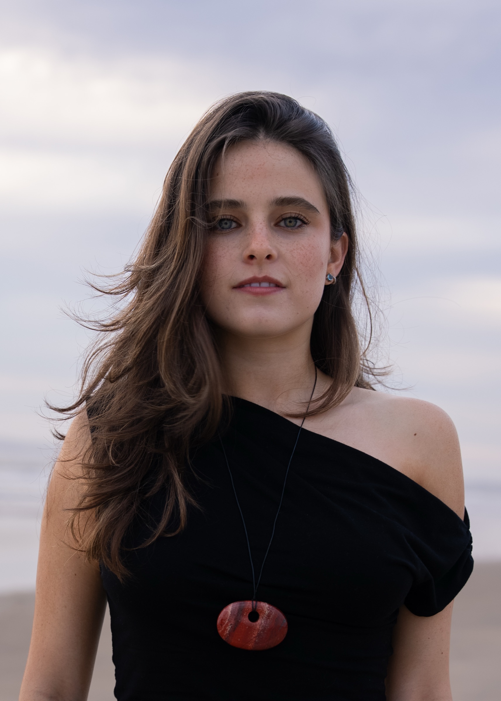 A woman on the beach wearing an Almara pendant